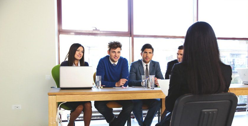 Group collaborating at table with laptops