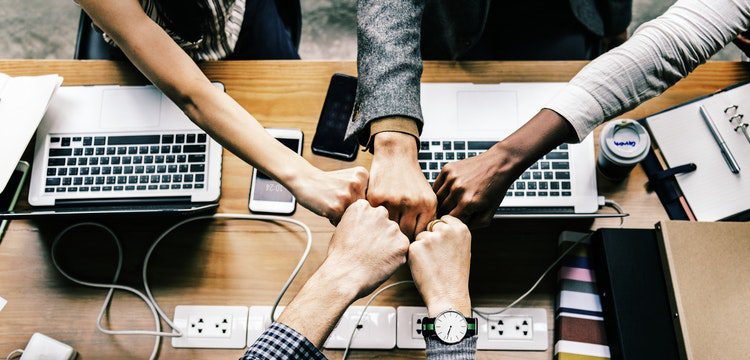 Group collaborating with hands together.